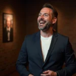 Humoriste masculin en train de raconter une blague sur scène dans un comedy club intime aux murs de briques